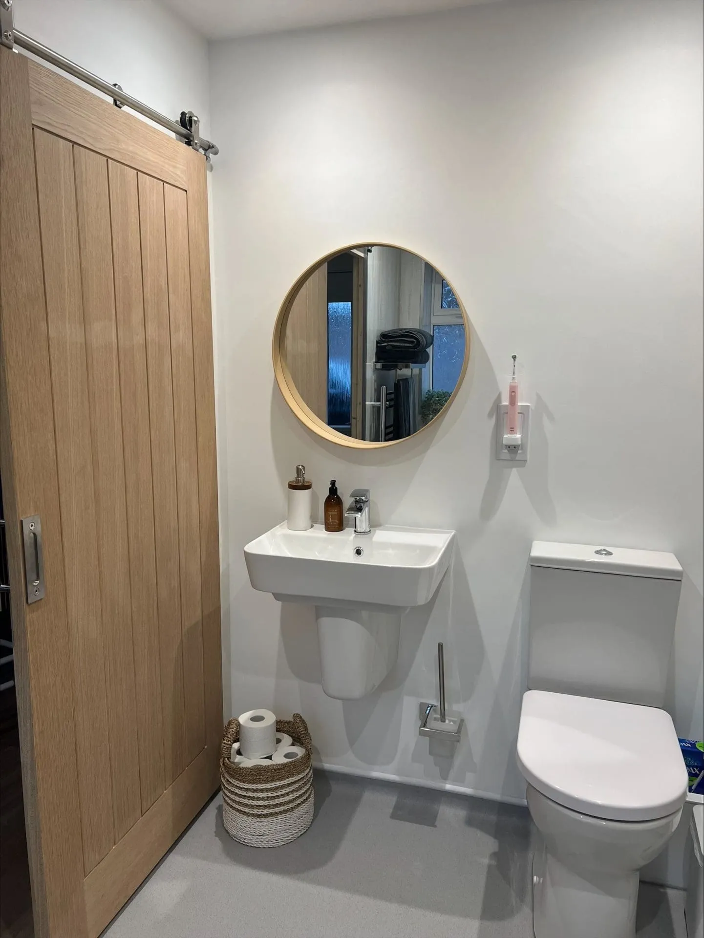 Bathroom with a comfort height toilet, sliding door, and sink.