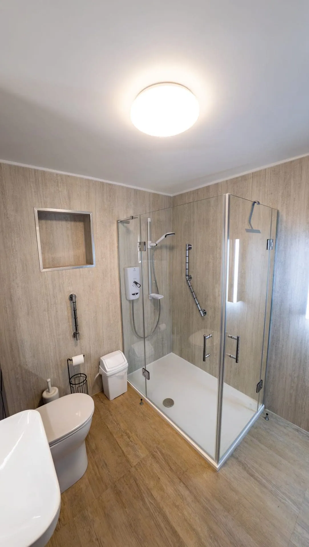 An accessible shower with corner entry doors to allow wider access - closed